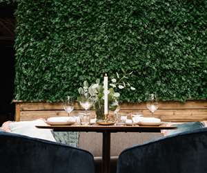 Table setting viewed over blue velvet chairs